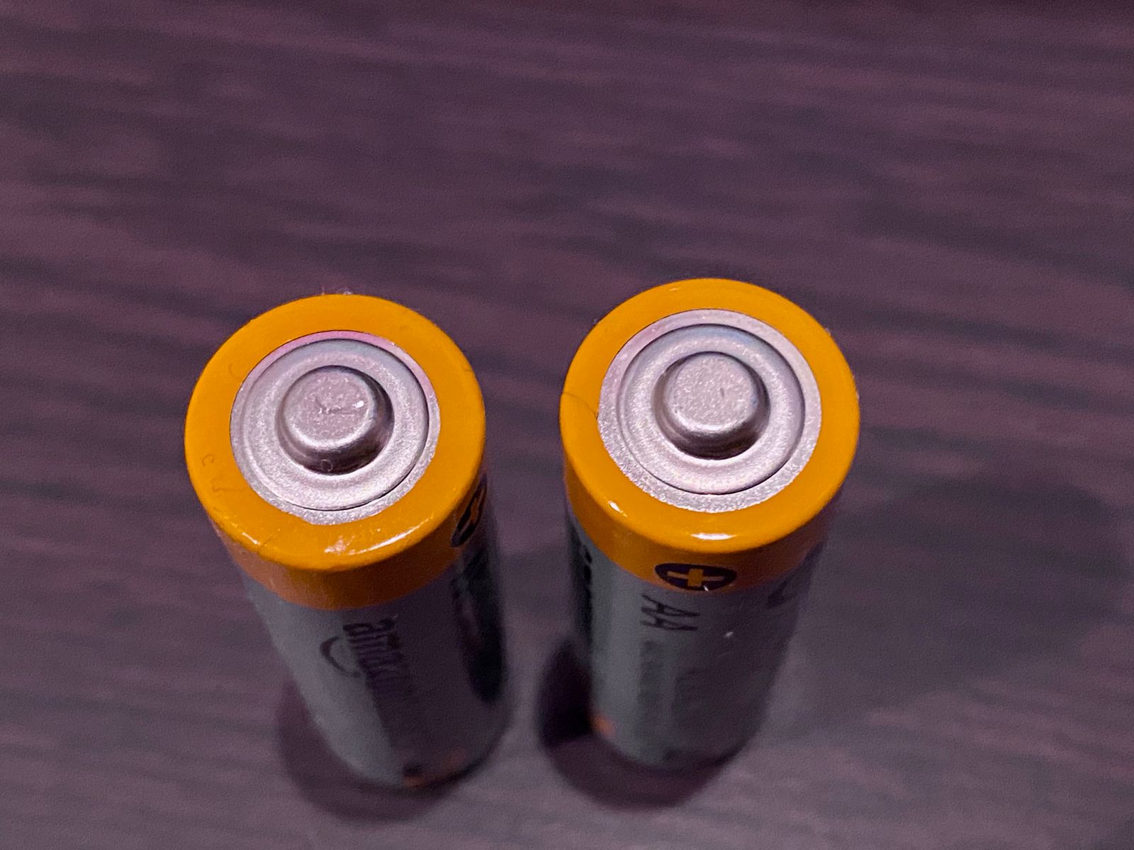 AA batteries on a dark surface