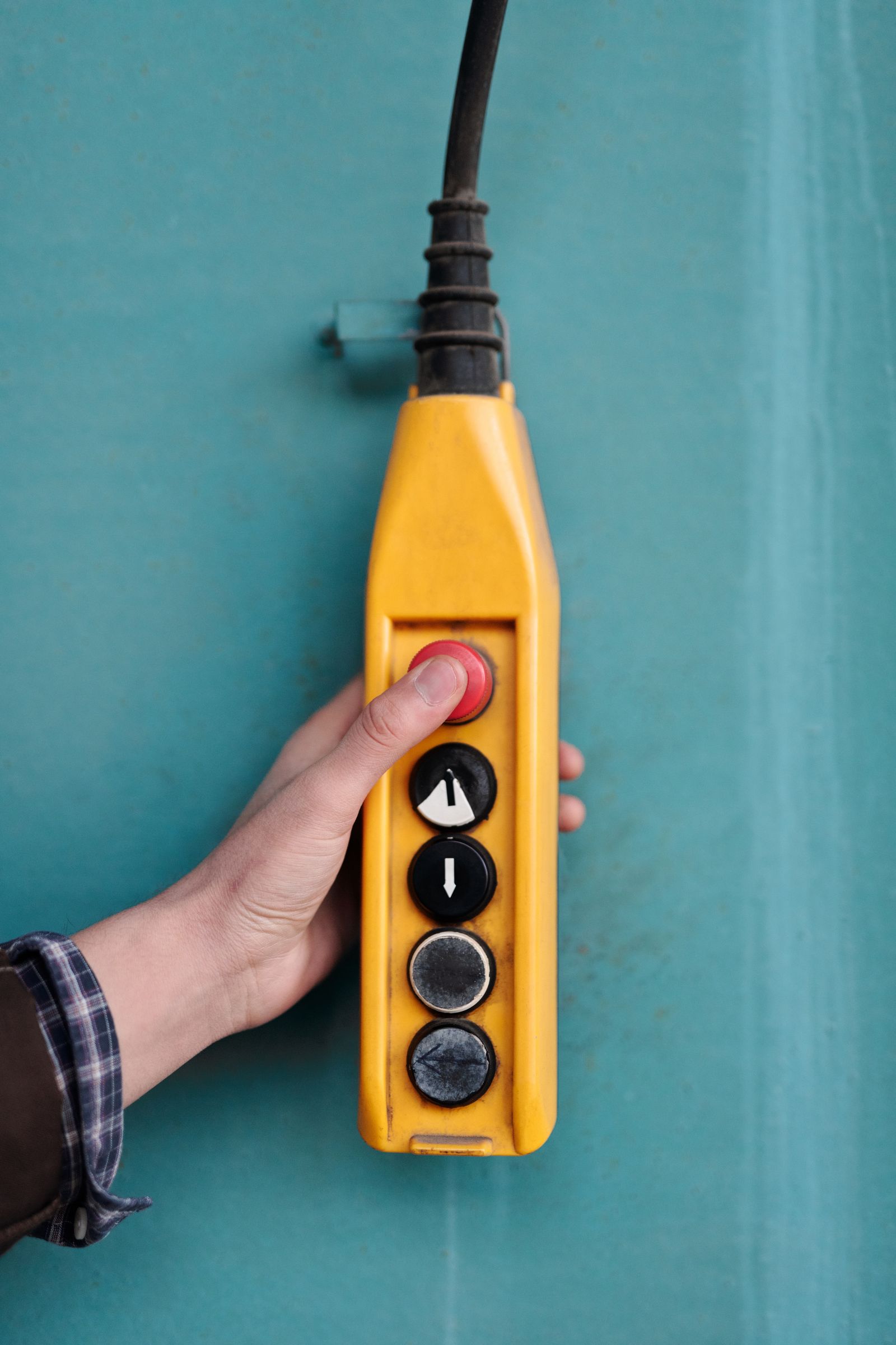 Hand pressing an industrial control panel button