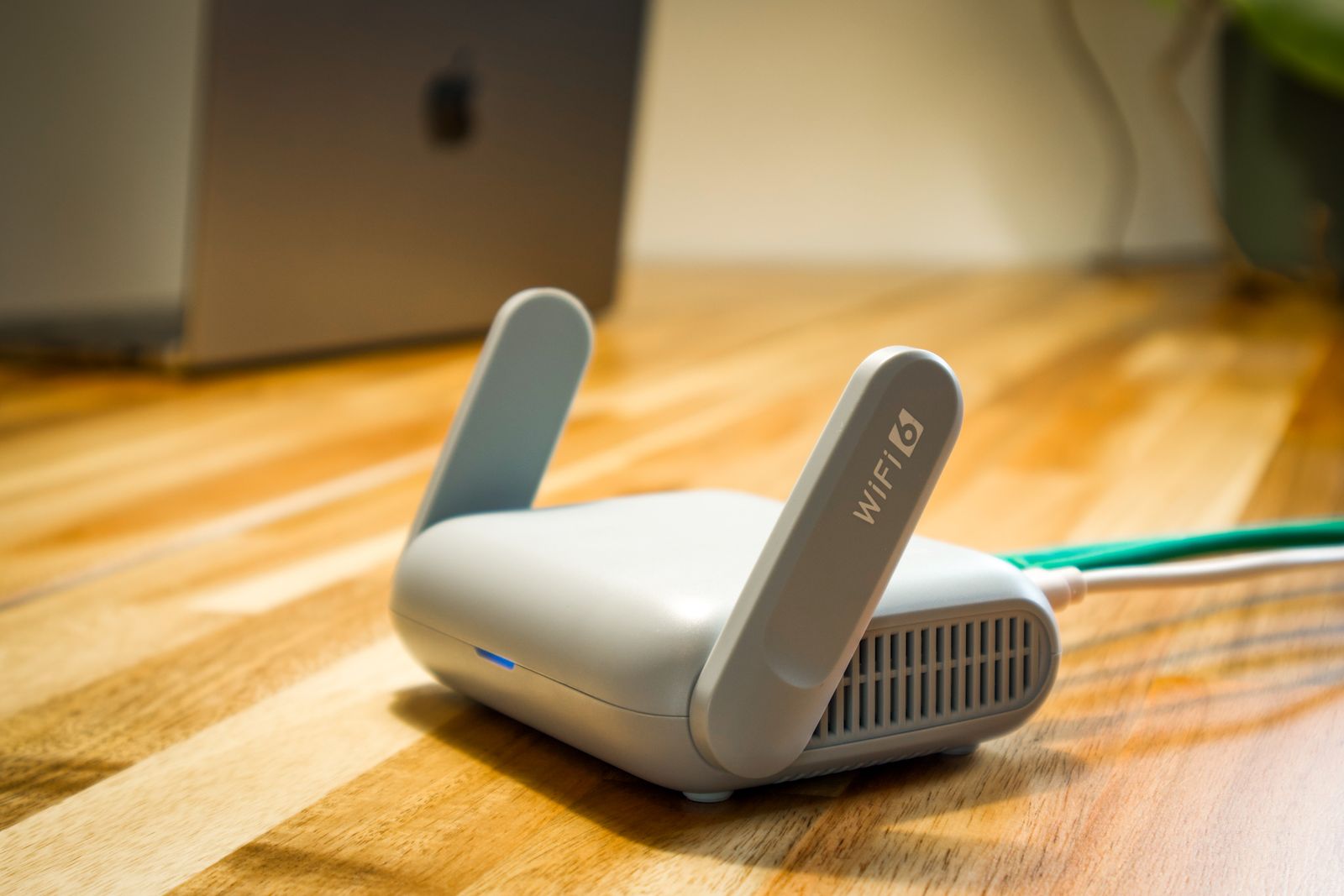 Modern Wi-Fi router on a wooden desk